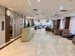 a lobby with a car dealership withchairs and a clock at Milestone Rise Jeddah in Jeddah