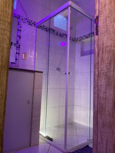 a shower with a purple lighting in a bathroom at Covil das Trilhas Coliving SÓ PARA MULHERES in Lençóis