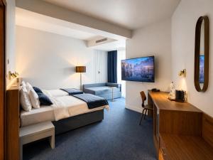 a hotel room with a bed and a desk at Hotel Kadmo by Aycon in Budva