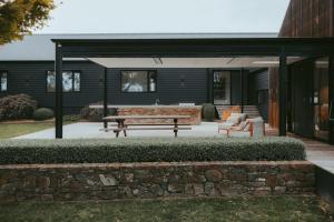 a patio with a picnic table and a bench at Injala House - Designer Masterpiece, Exeter in Exeter