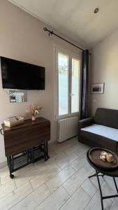a living room with a couch and a table at Mini studio et espace extérieur in Méry-sur-Oise