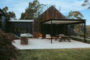 a black shed with a picnic table and a bench at Injala House - Designer Masterpiece, Exeter in Exeter +54 photos