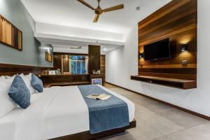 a bedroom with a large bed and a flat screen tv at SinQ Prive in Candolim