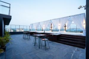 a bar on the roof of a building with tables and chairs at SinQ Prive in Candolim
