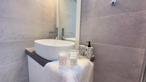 a bathroom with a white sink and a mirror at Modern Cycladic Sea View House in Ornos +55 photos