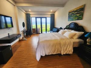 a bedroom with a large bed and a desk at Karst Residence Phong Nha in Phong Nha