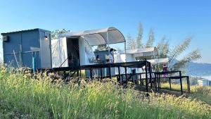 a mobile home in a field of tall grass at เขาเจ้าขา-เต็นท์กระโจมเขาค้อ โดมvip in Khao Kho