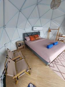 a room with two beds and a chair in a igloo at เขาเจ้าขา-เต็นท์กระโจมเขาค้อ โดมvip in Khao Kho