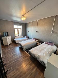 a room with three beds and a tv in it at Rüütli kodumajutus in Paide