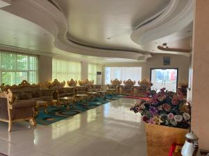 a large room with couches and tables and flowers at Hotel Al Masa in Al Buraymī