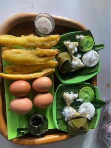 a basket of food with eggs and peppers and fries at Pondok DG and Spa in Munduk