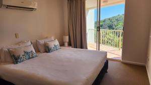 a bedroom with a bed with a view of a balcony at Whalewatch Ocean Beach Resort in Point Lookout +189 photos