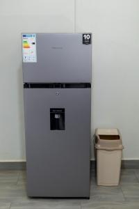a refrigerator and a trash can next to a wall at NL Josephine's Hotel, Apartment in Kampala +16 photos