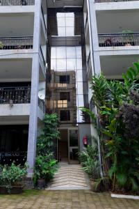 a tall building with a courtyard with plants at NL Josephine's Hotel, Apartment in Kampala