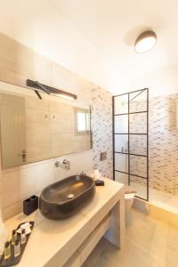 a bathroom with a large black sink on a counter at Agia Marina Caldera suites in Megalochori