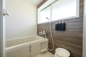 a bathroom with a shower and a toilet and a window at 糸島 古雅 Koga in Itoshima +33 photos