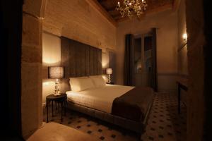 a bedroom with a bed and a chandelier at The Duchess of Puglia in Polignano a Mare