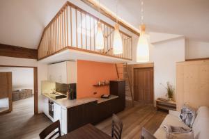 eine Küche und ein Wohnzimmer mit Treppe in der Unterkunft Aussermahrhof - familyfarm in Gsies