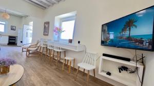 a living room with a large flat screen tv on the wall at Modern Cycladic Sea View House in Ornos