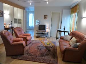 ein Wohnzimmer mit 2 Stühlen und einem TV in der Unterkunft Gîte d'Maïsala Les Mésanges in Heidwiller