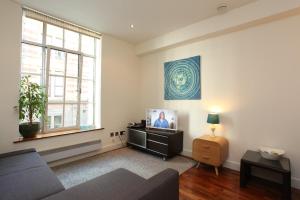 a living room with a couch and a tv at Park Row Apartments in Leeds