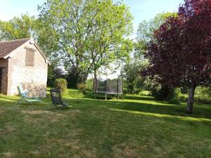 two chairs sitting in the grass in a yard at Au petit horizon in La Bazoche-Gouet