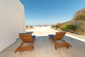 two chairs and a table on a porch with a view at Agia Marina Caldera suites in Megalochori