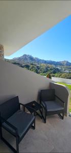 two chairs and a table on a balcony with a view at Alma-Librehouse in Kefalos