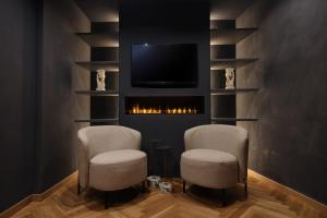 a living room with two chairs and a tv at The Duchess of Puglia in Polignano a Mare