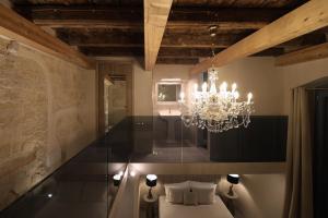 a chandelier in a room with a bed and a sink at The Duchess of Puglia in Polignano a Mare +52 photos