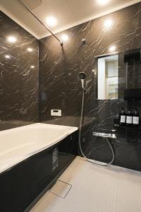 a bathroom with a bath tub and a mirror at KiyosuBase2 in Kiyosu +11 photos