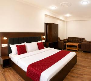 a bedroom with a large bed with red pillows at The Ladakh Residency Kargil in Kargil