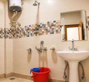a bathroom with a sink and a mirror and a bucket at The Ladakh Residency Kargil in Kargil +11 photos