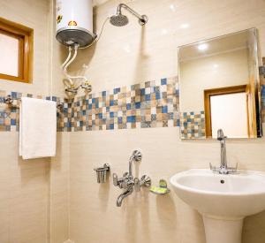 a bathroom with a sink and a mirror at The Ladakh Residency Kargil in Kargil