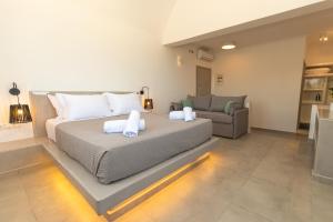 a bedroom with a bed and a couch at Agia Marina Caldera suites in Megalochori