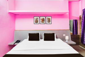 a pink room with a bed with three pictures on the wall at Collection O SNT Bus Terminal Siliguri in Siliguri