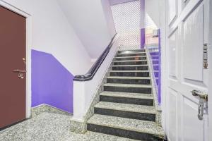 a staircase with purple walls and a door at Collection O SNT Bus Terminal Siliguri in Siliguri