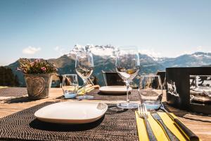 Ein Tisch mit Tellern und Weingläsern auf einem Berg in der Unterkunft Chalet Chanso in Morgins