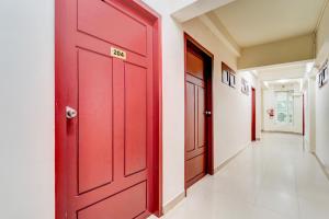 a red door in the hallway of a house at Collection O Kottayam Formerly Sap Inn in Kottayam