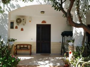 a front door of a house with a table and a bench at B&B Il Melograno Salento in Torre Inserraglio