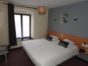 a bedroom with a white bed and a window at Le Barriol in Saint-Julien-Chapteuil