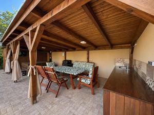 a patio with a table and chairs and a kitchen at Barka Vendégház Tisza-tó in Abádszalók