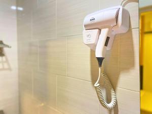 a phone is hanging on a wall in a bathroom at Seeds Hotel Selayang in Batu Caves