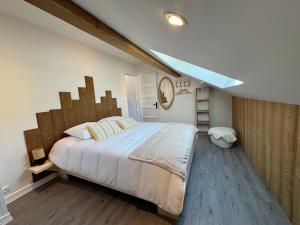 a bedroom with a large bed with a wooden headboard at L'ANTRE Deux LACS avec parking et garage in Xonrupt-Longemer