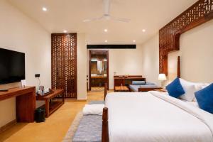 a bedroom with a large bed and a television at Hotel Aurea Jaisalmer in Jaisalmer