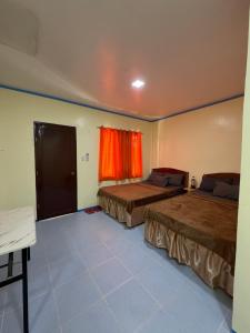 a bedroom with two beds and a window at Anda Seabreeze Pension Haus in Anda