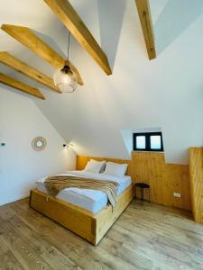 a bedroom with a bed in a room with wooden floors at Casuta Boema in Râşnov +71 photos