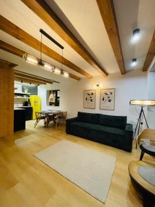 a living room with a black couch and a table at Casuta Boema in Râşnov