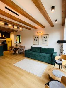 a living room with a green couch and a table at Casuta Boema in Râşnov