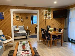 a living room with a table and a couch at Winganah Cottage in Murdunna +37 photos
